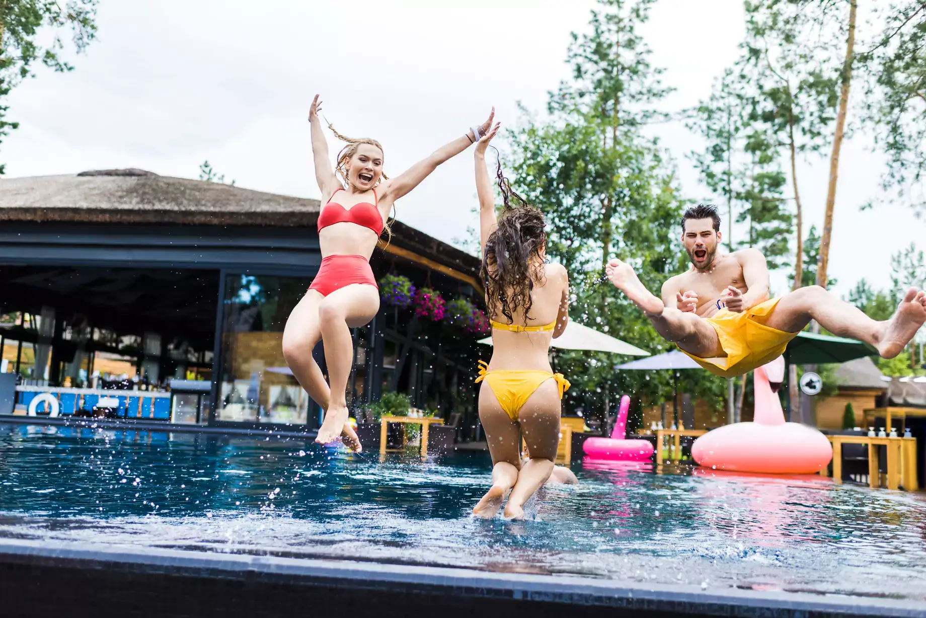 Friends jumping into container pool